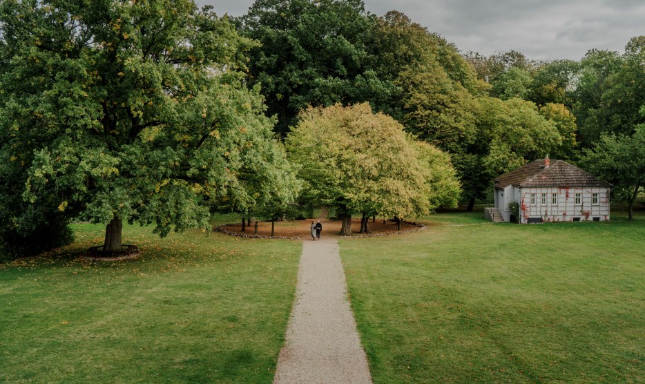 Een idyllische wandeling door het park van Romantik Hotel Gutshaus Ludorf: omringd door oude bomen en groene weiden nodigt de natuur je uit om te ontspannen en tot rust te komen.