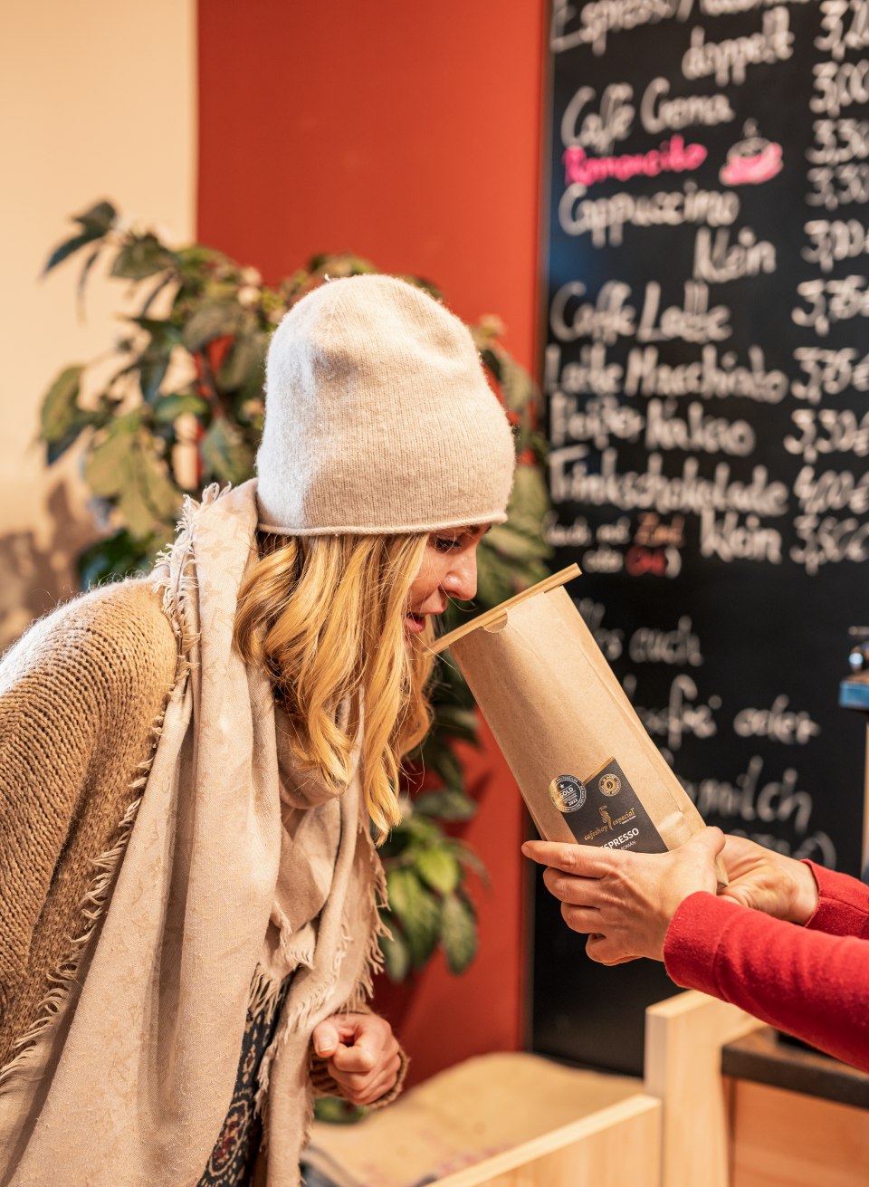 A woman smells an open bag of fresh coffee - The aroma of fine coffee beans is always in the air at cafeshop Especial