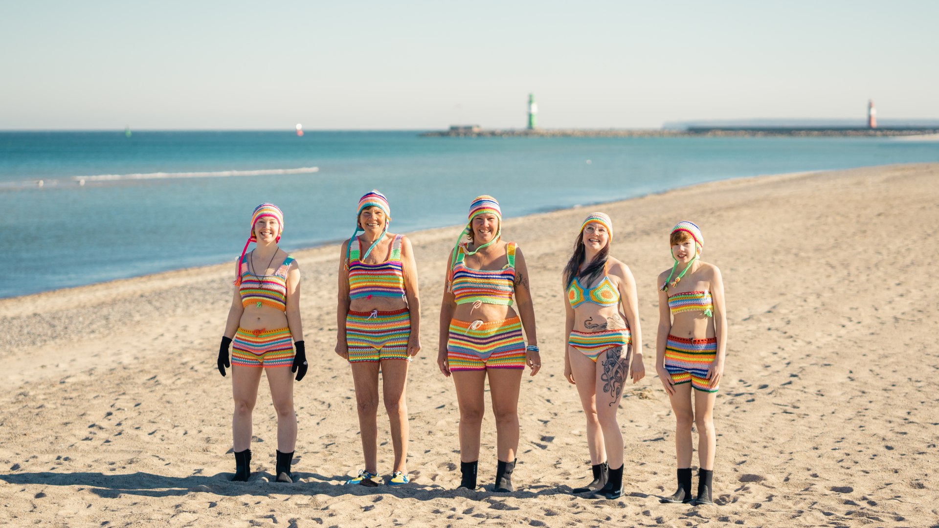 Rodzina pływa pod lodem w szydełkowanych strojach kąpielowych na plaży w Warnemünde, © TMV/Gross