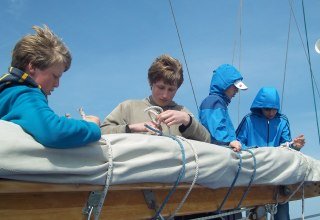 Young people on the chart house, packing the mainsail, © Mirko Niebuhr 2017