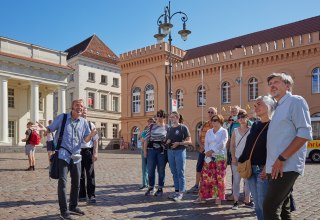 City guide with a group of guests at the Schwerin market in front of the town hall., © Oliver Borchert
