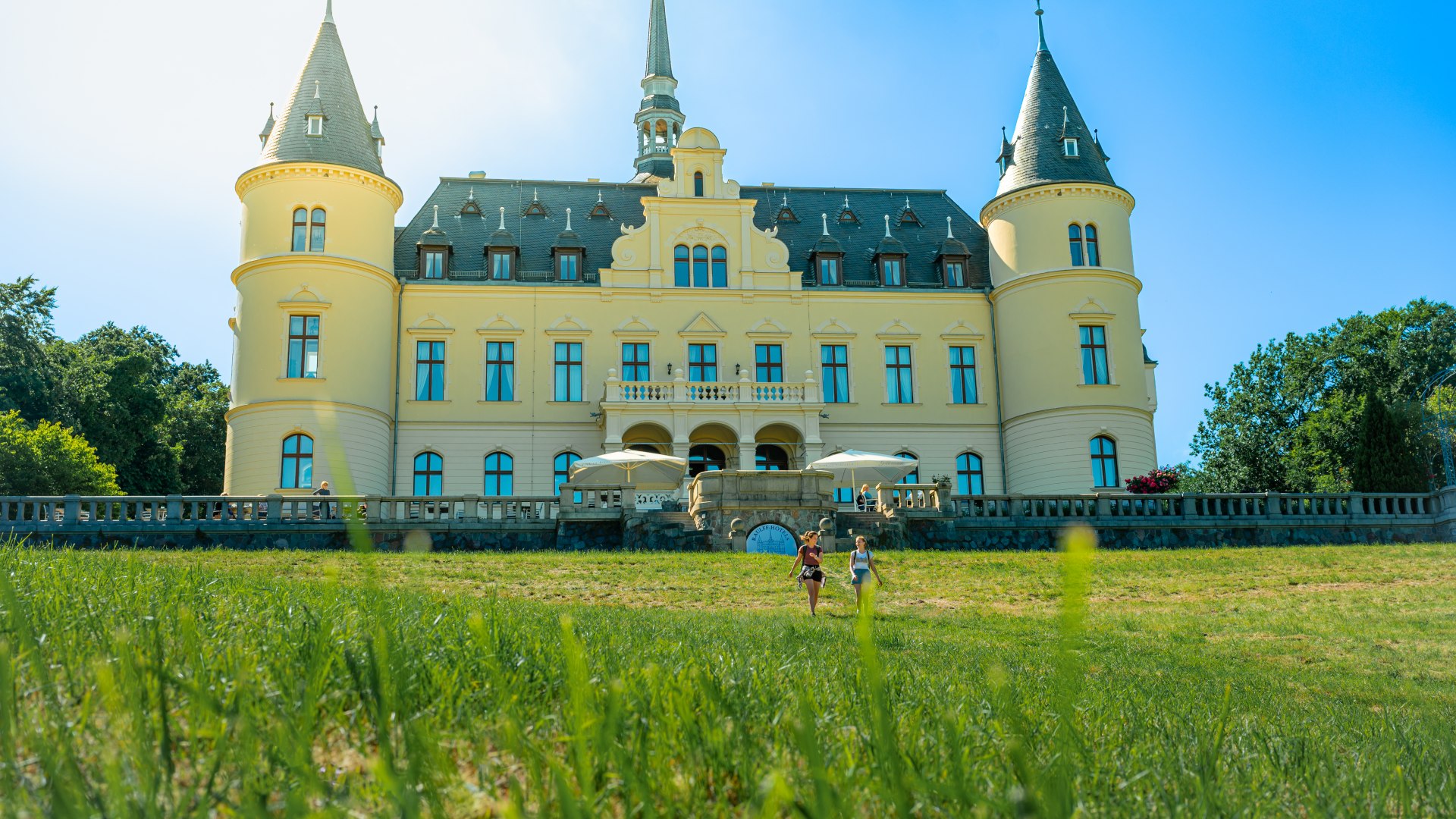 Two women walking in front of Ralswieck Castle