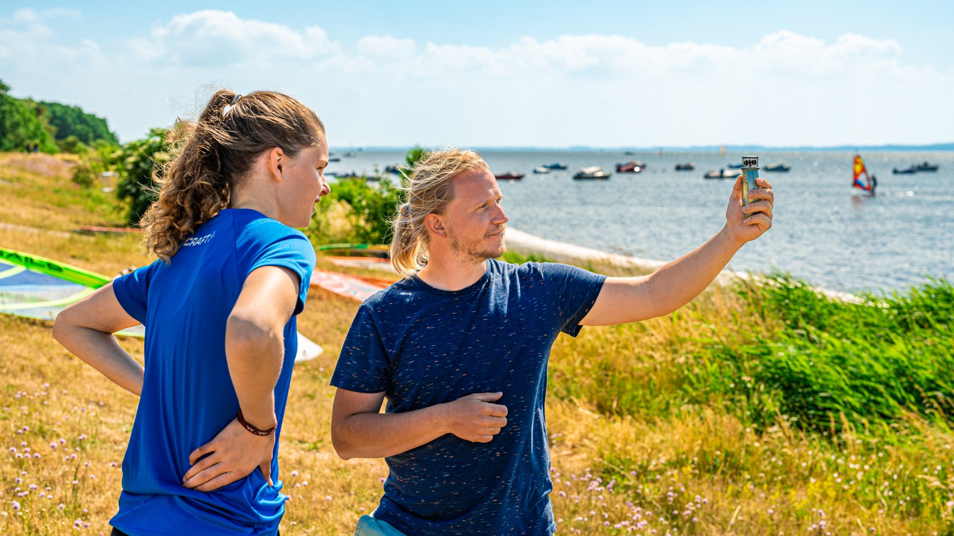 Jeśli jest zbyt słaby, początkującym trudno będzie utrzymać latawiec w powietrzu. Instruktor kitesurfingu mierzy wiatr za pomocą wiatromierza.