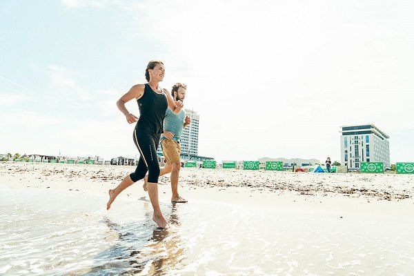 Sportowiec biegnie latem po plaży w Warnemünde