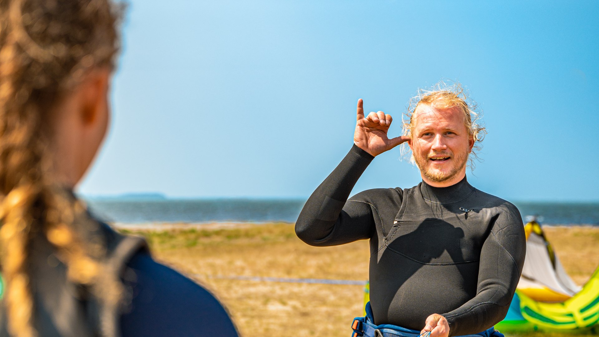 Lekcje kitesurfingu w języku migowym - instruktor tłumaczy kursantowi na Ummanz.